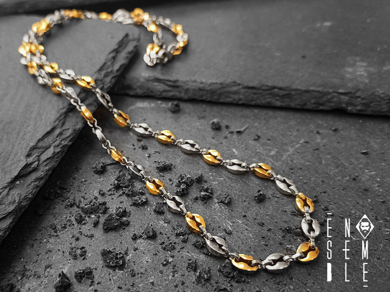 Collana maglia Chicchi di Caffè realizzata in acciaio inossidabile di ottima qualità. Progettata con maglie alternate bicolor Argento/Dorato, chiusura a moschettone.