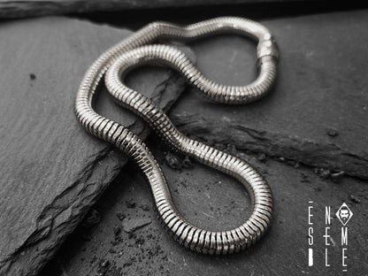 La collana Snake è un gioiello unico: leggero e flessibile, è caratterizzato da una preziosa maglia metallica in cui scorre un’anima morbida. In questa versione, la maglia è in acciaio argentato da Ø 6 mm e la lunghezza è perfetta per essere modellata intorno al collo. Un gioiello dal carattere maschile e dallo stile unisex adatto anche a un pubblico femminile dalla forte personalità.