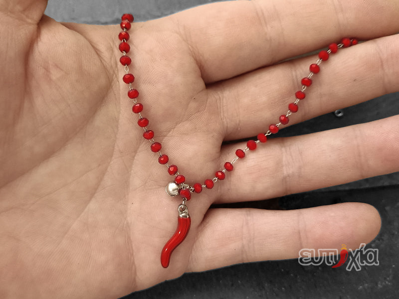 Elegante e raffinato bracciale realizzato rigorosamente in acciaio inossidabile di altissima qualità e cristalli sfaccettati con cornetto rosso e sonaglino portafortuna