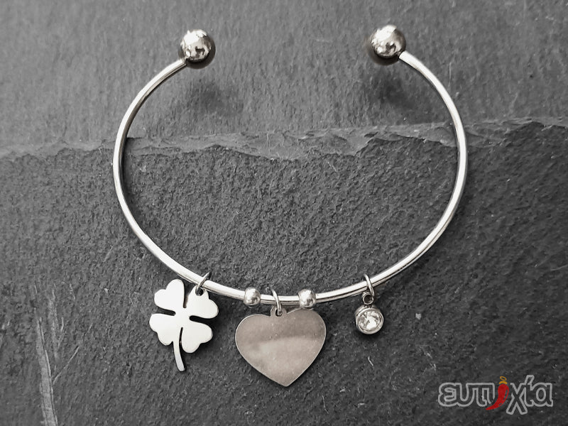 Elegante e raffinato bracciale Bangle piercing realizzato rigorosamente con filo rigido in acciaio inossidabile di altissima qualità, ciondolo design cuore, punto luce e quadrifoglio portafortuna