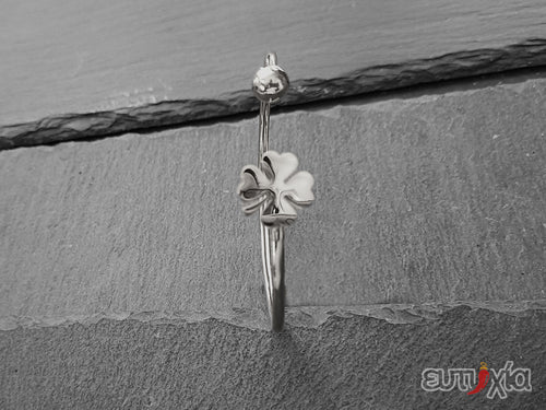 Elegante e raffinato bracciale Bangle piercing realizzato con filo rigido in acciaio inossidabile di altissima qualità con all'estremità una pallina e un charm design quadrifoglio portafortuna