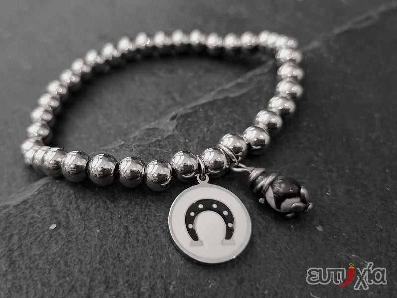 Bracciale elastico con perline in acciaio 316L, pendente rotondo con ferro di cavallo smaltato in acciaio e perlina.