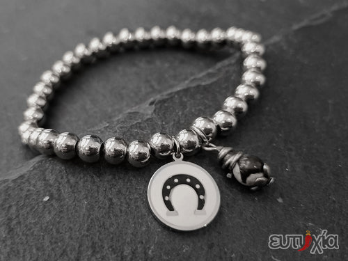 Bracciale elastico con perline in acciaio 316L, pendente rotondo con ferro di cavallo smaltato in acciaio e perlina.