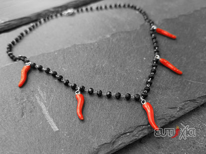 Elegante collana realizzata rigorosamente in acciaio inossidabile di altissima qualità e cristalli sfaccettati neri con cinque cornetti rossi portafortuna