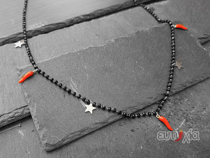 Collana realizzata rigorosamente in acciaio inossidabile di altissima qualità e cristalli sfaccettati neri con tre cornetti rossi portafortuna e quattro stelline