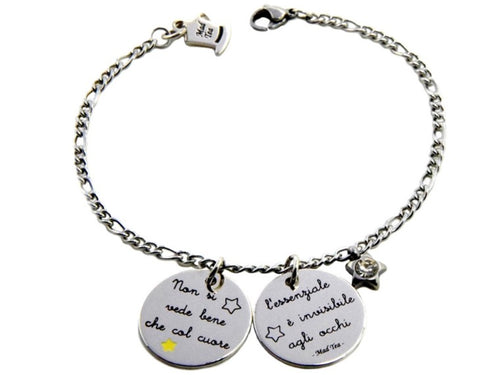 Il bracciale “L’essenziale è invisibile agli occhi” si ispira alla celebre frase del racconto di Antoine de Saint-Exupéry “Il Piccolo Principe”. È in acciaio anallergico, formato da una catena ad anellini e due ciondoli tondi e piatti con incisa la scritta “Non si vede bene che col cuore, l’essenziale è invisibile agli occhi”; accanto troviamo anche un piccolo ciondolino a forma di stellina con al centro un cristallo. 