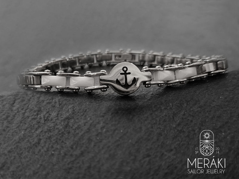 Il gioiello è composto da una maglia a catena in acciaio alternata nella parte centrale da piastrine in ceramica bianca che donano lucentezza e charme al bracciale. Al centro, il gioiello è completato da una piccola placca tonda su cui è disegnata un’ancora