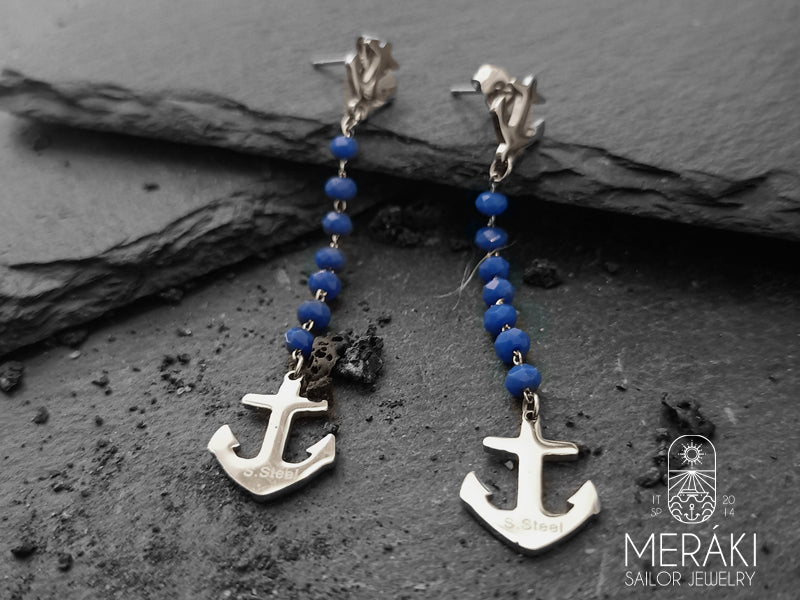 Una coppia di orecchini colorati sono la giusta soluzione per vivacizzare anche gli outfit più formali e da ufficio, realizzati con perno ad ancora, catenella a rosario blu e altre due ancore pendenti in acciaio inossidabile chirurgico