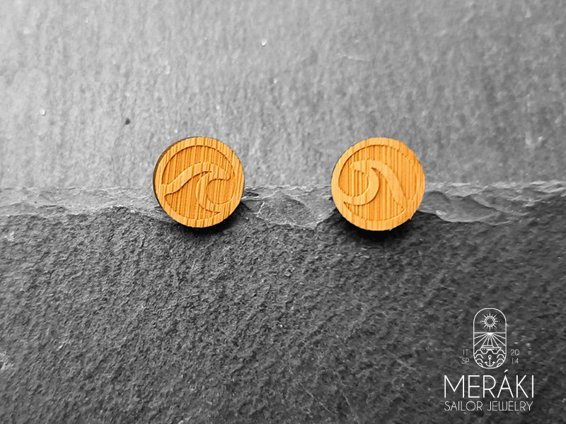 Orecchini a perno in acciaio chirurgico la cui caratteristica distintiva è il design a forma di onda realizzato in legno