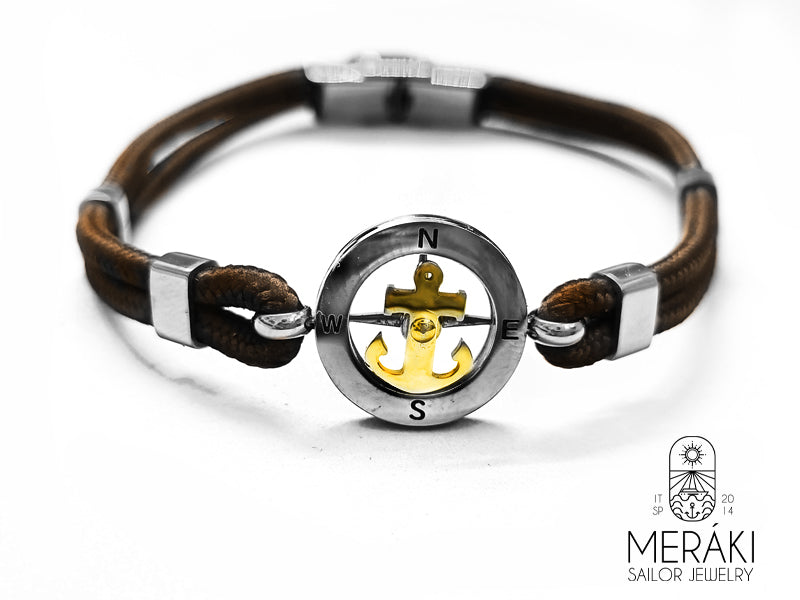 Bracciale Meraki cordino nautico marrone con charm centrale rotondo con rosa dei venti e ancora dorata girevole